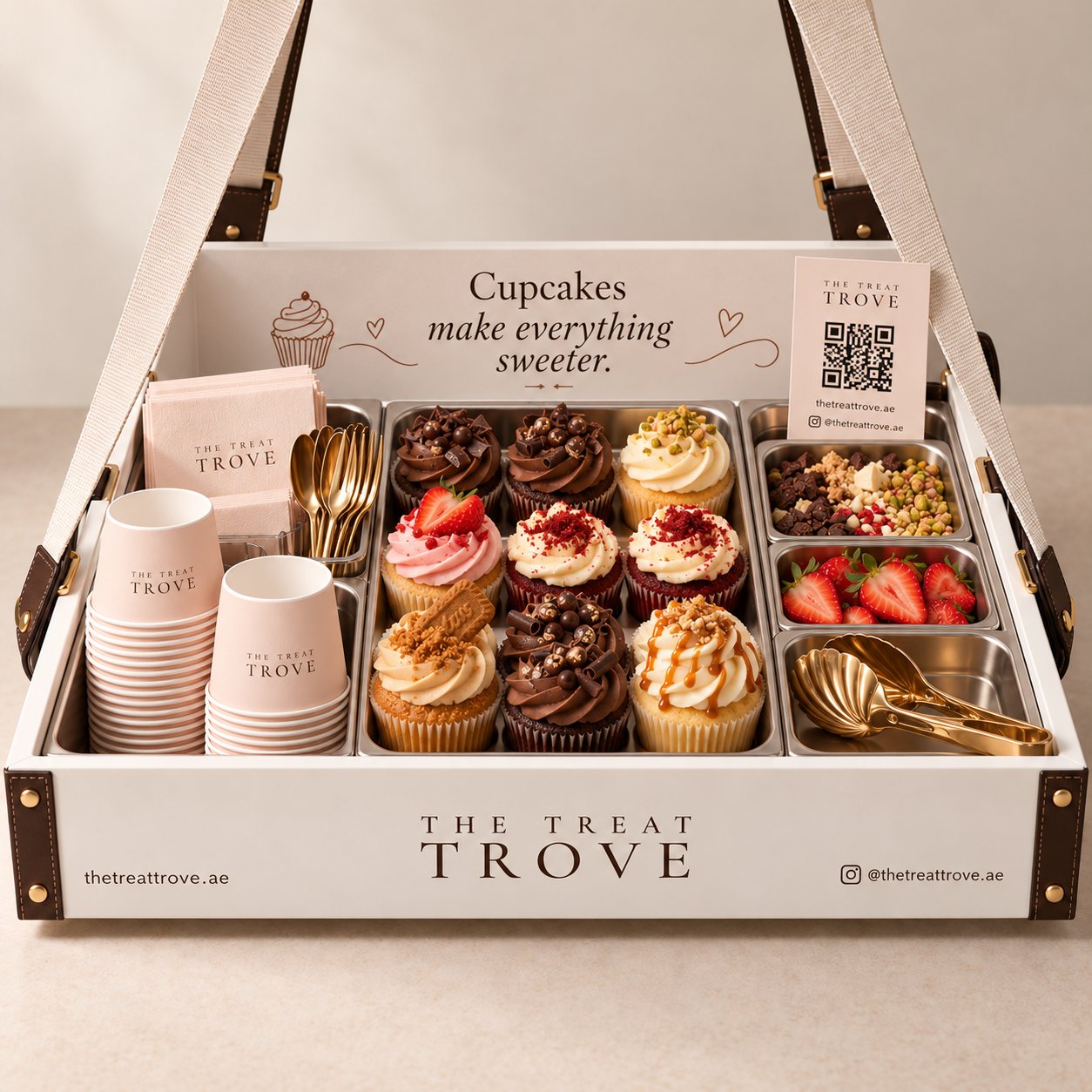 A white Treat Trove serving tray featuring nine decorated cupcakes, assorted toppings and fresh strawberries.