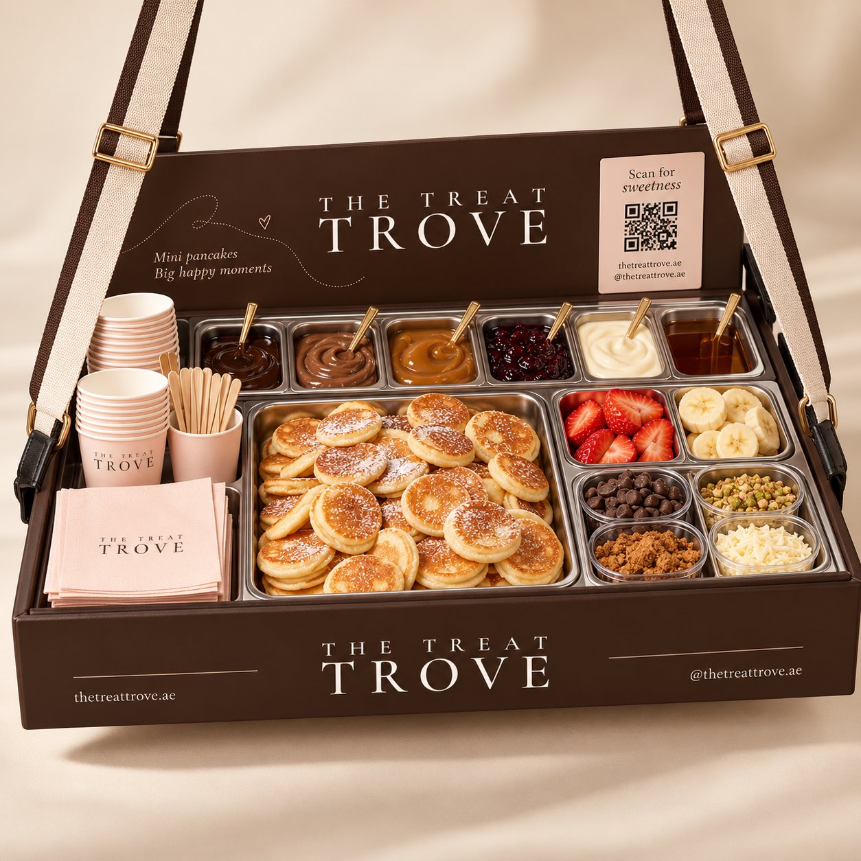 A Treat Trove serving tray with warm mini pancakes, a selection of sauces, fresh fruit and assorted toppings.